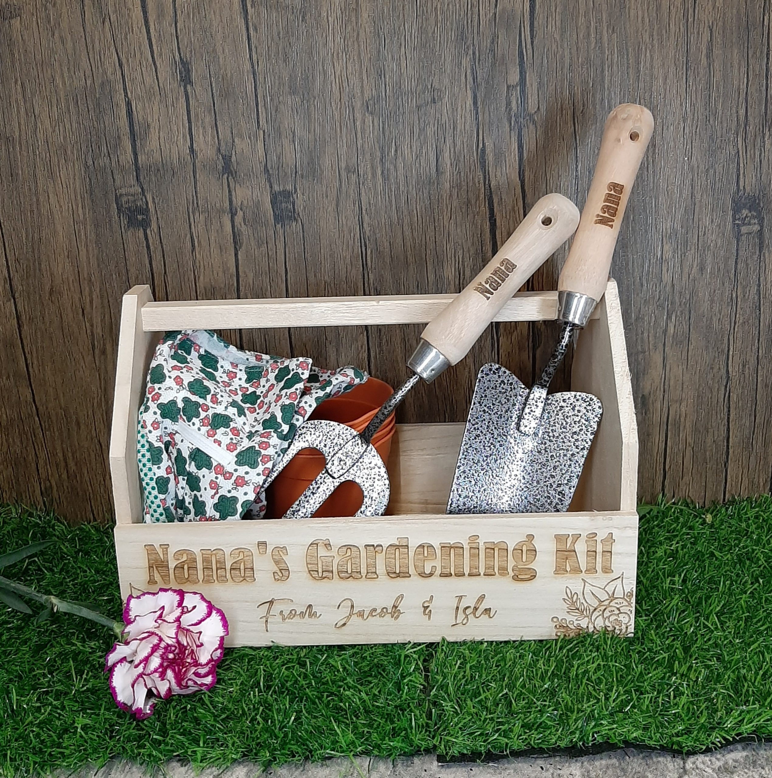 Gardening kit with flower box on grass with personalised box, fork and trowel