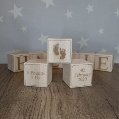 solid wooden personalised baby blocks with star wallpaper in nursery displaying footprints date of birth and weight details