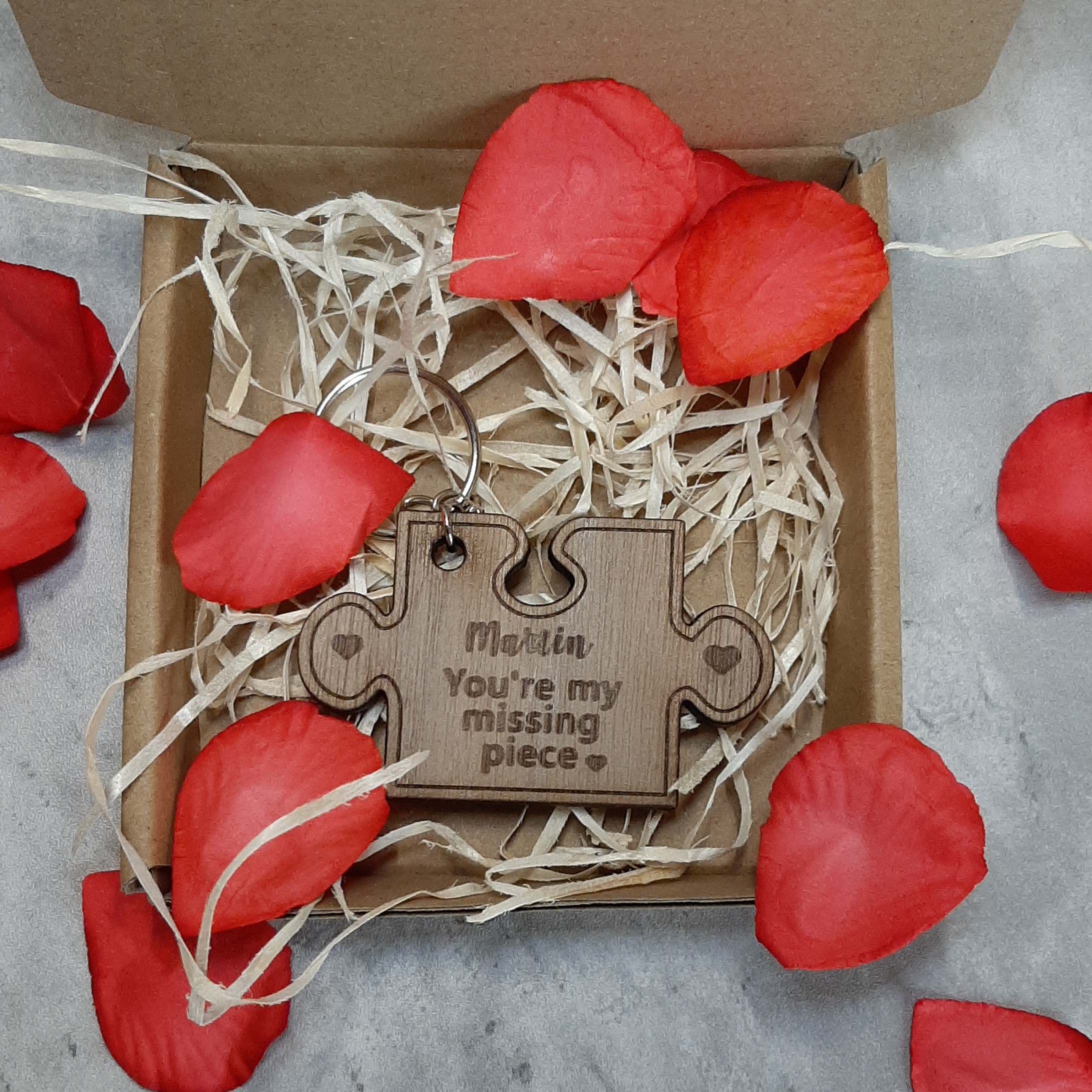 Missing Piece Puzzle Keyring surrounded by rose petals for valentines day, laser engraved with you're my missing piece - in box with straw