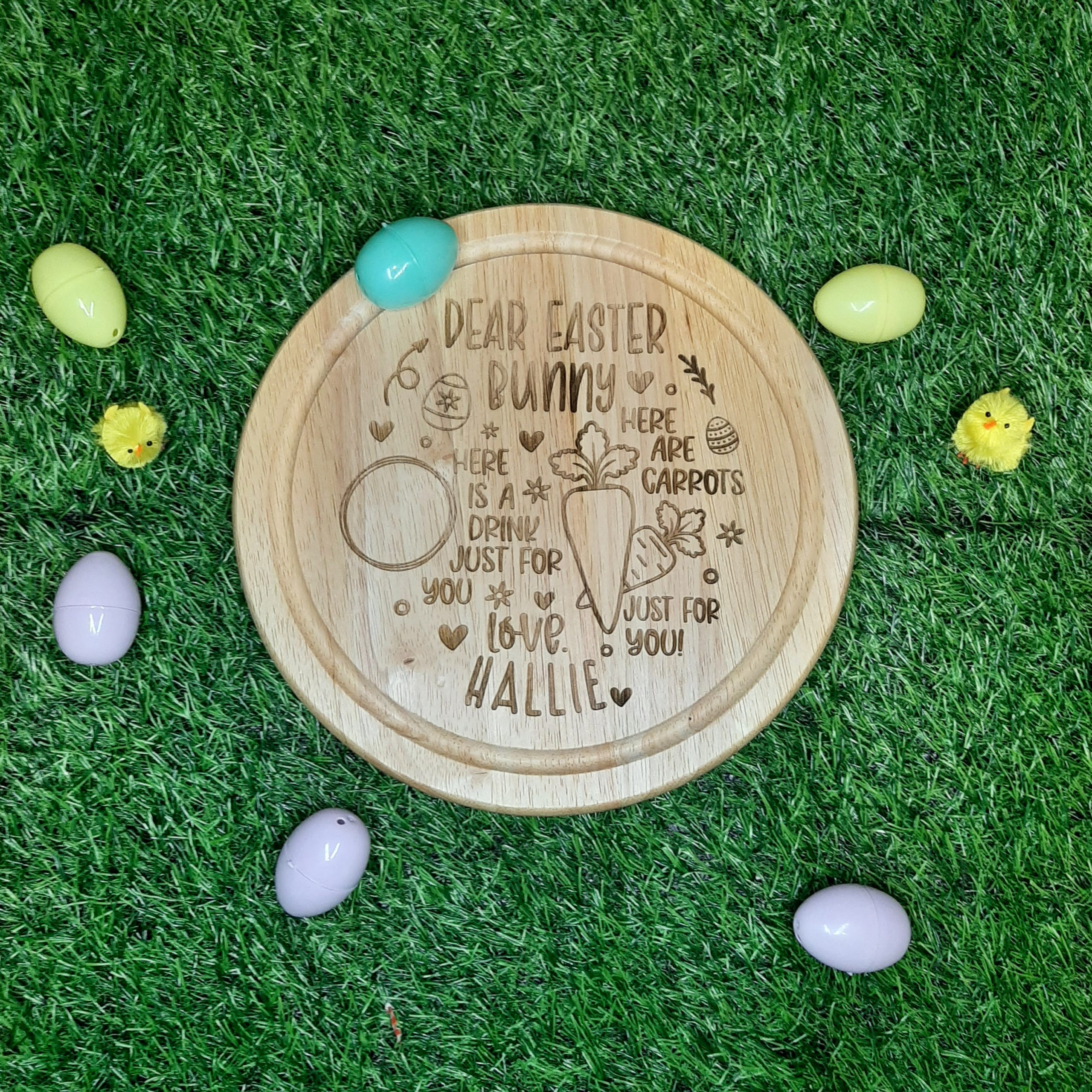 wooden easter bunny treat board with room for drink and carrots, laid on grass personalised with laser engraved name