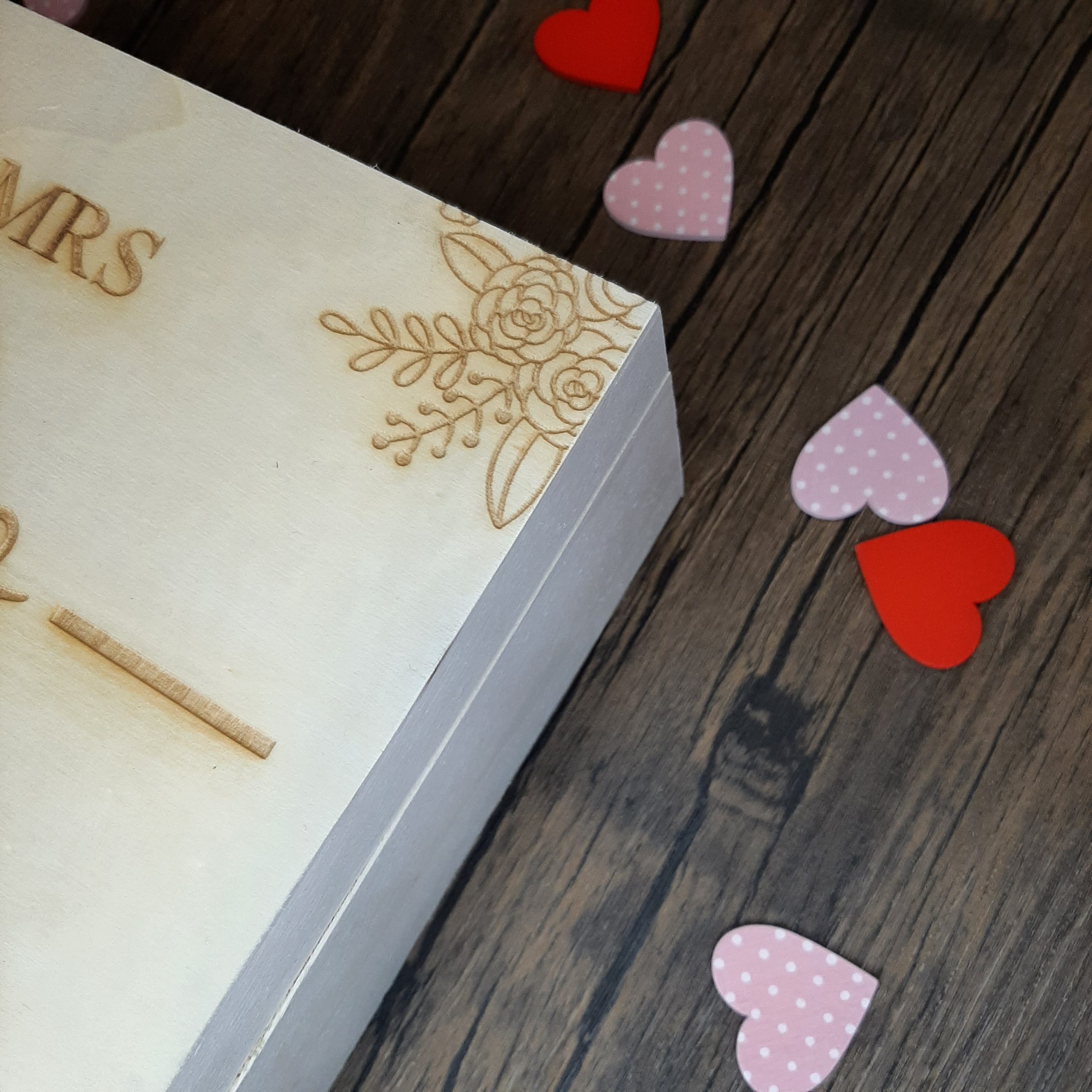 zoomed in to the engraving of flowers on the corner of the wedding keepsake box