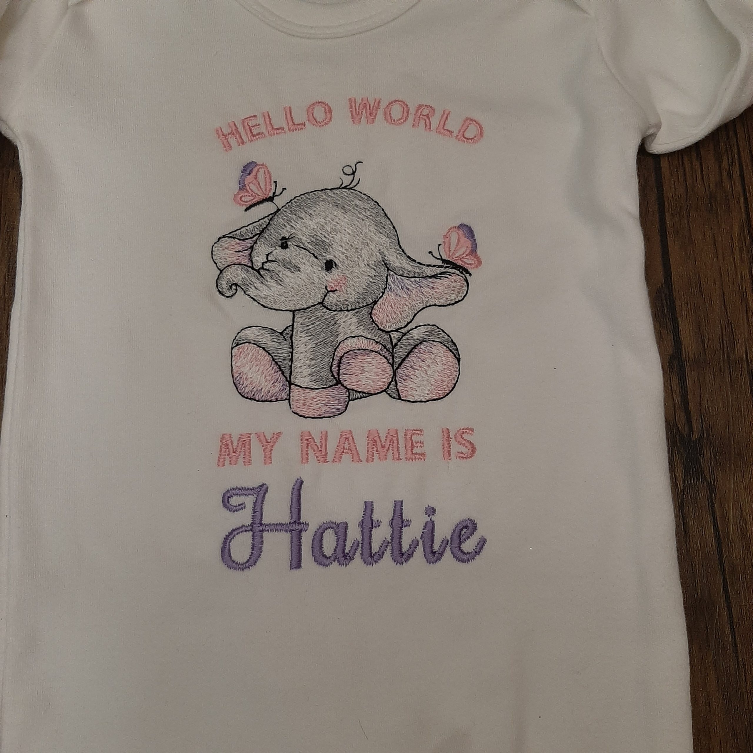 Zoomed in on the baby sleepsuit hello world embroidery design