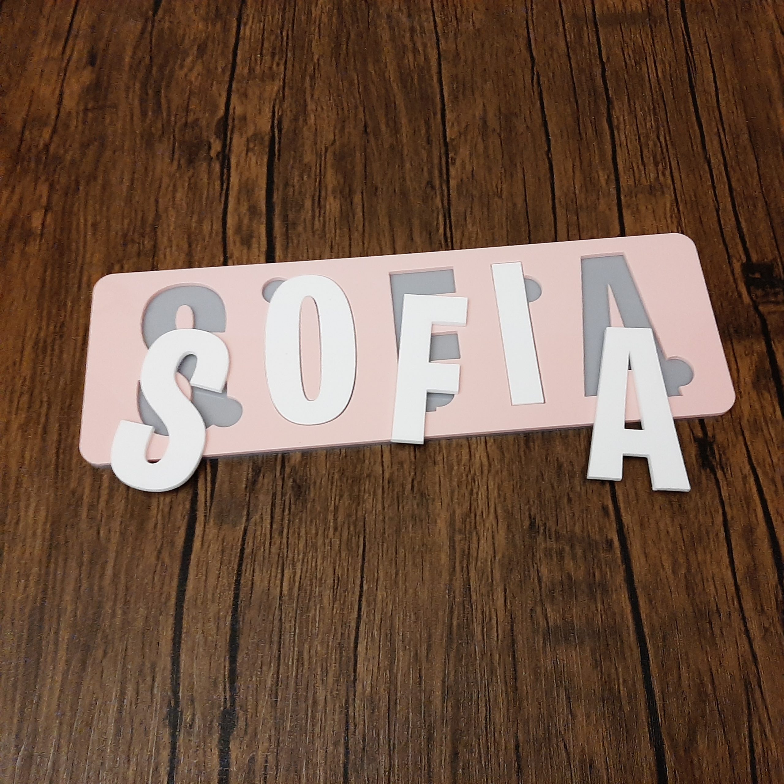 colourful name puzzle in pink white and grey laid on floor