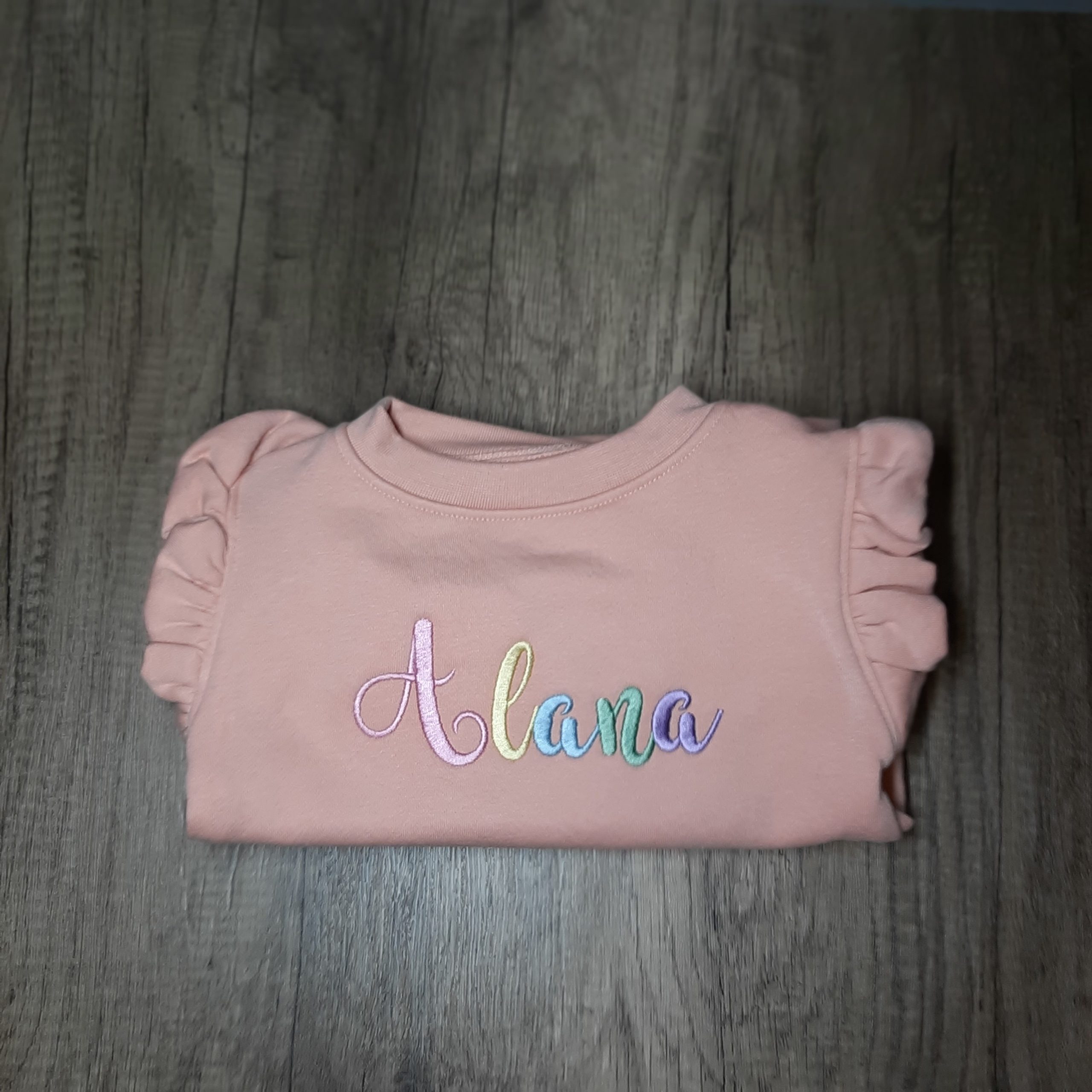 Dusky pink frill jumper with font 2 pastel rainbow name embroidered