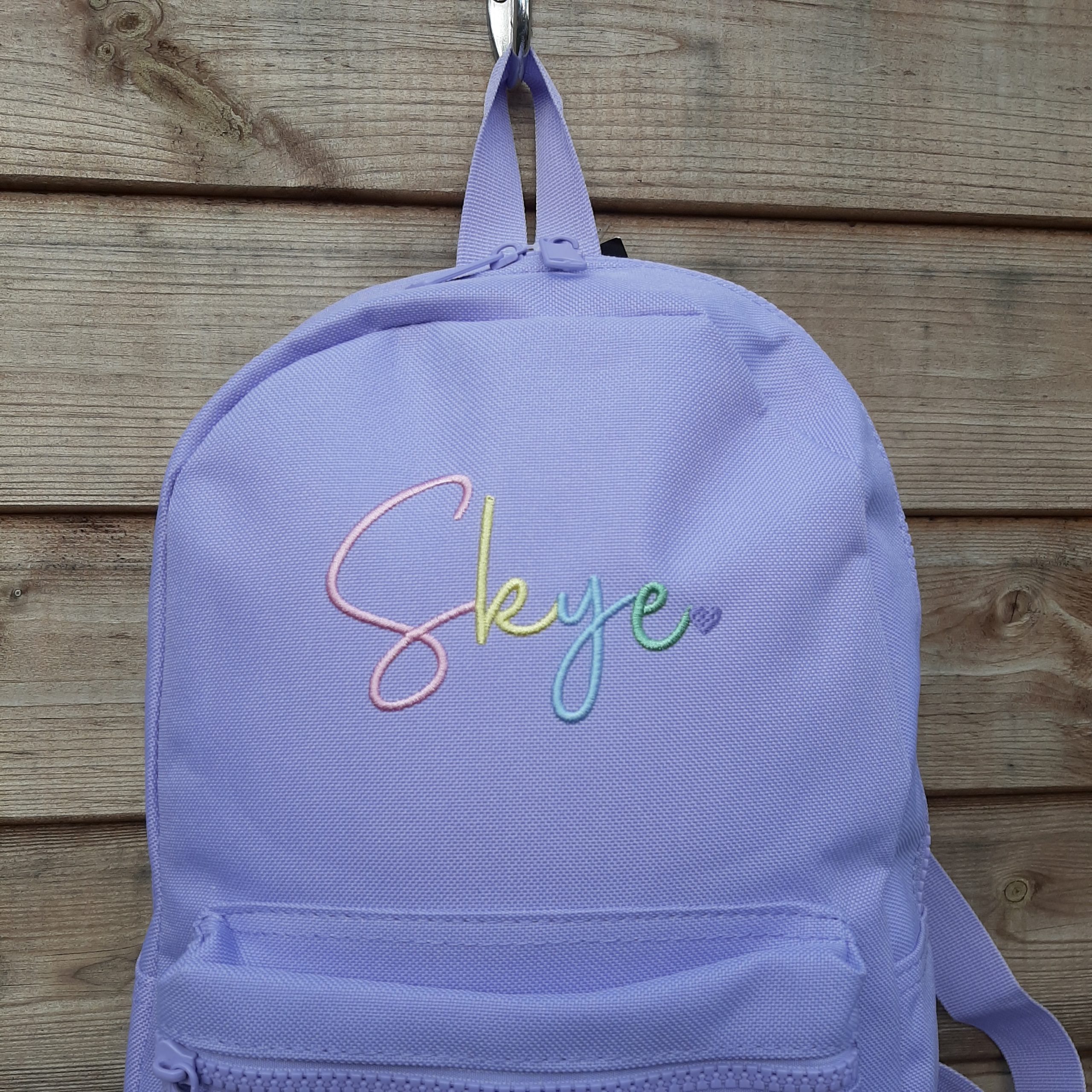 Zoomed in image of font E - backpack with rainbow name