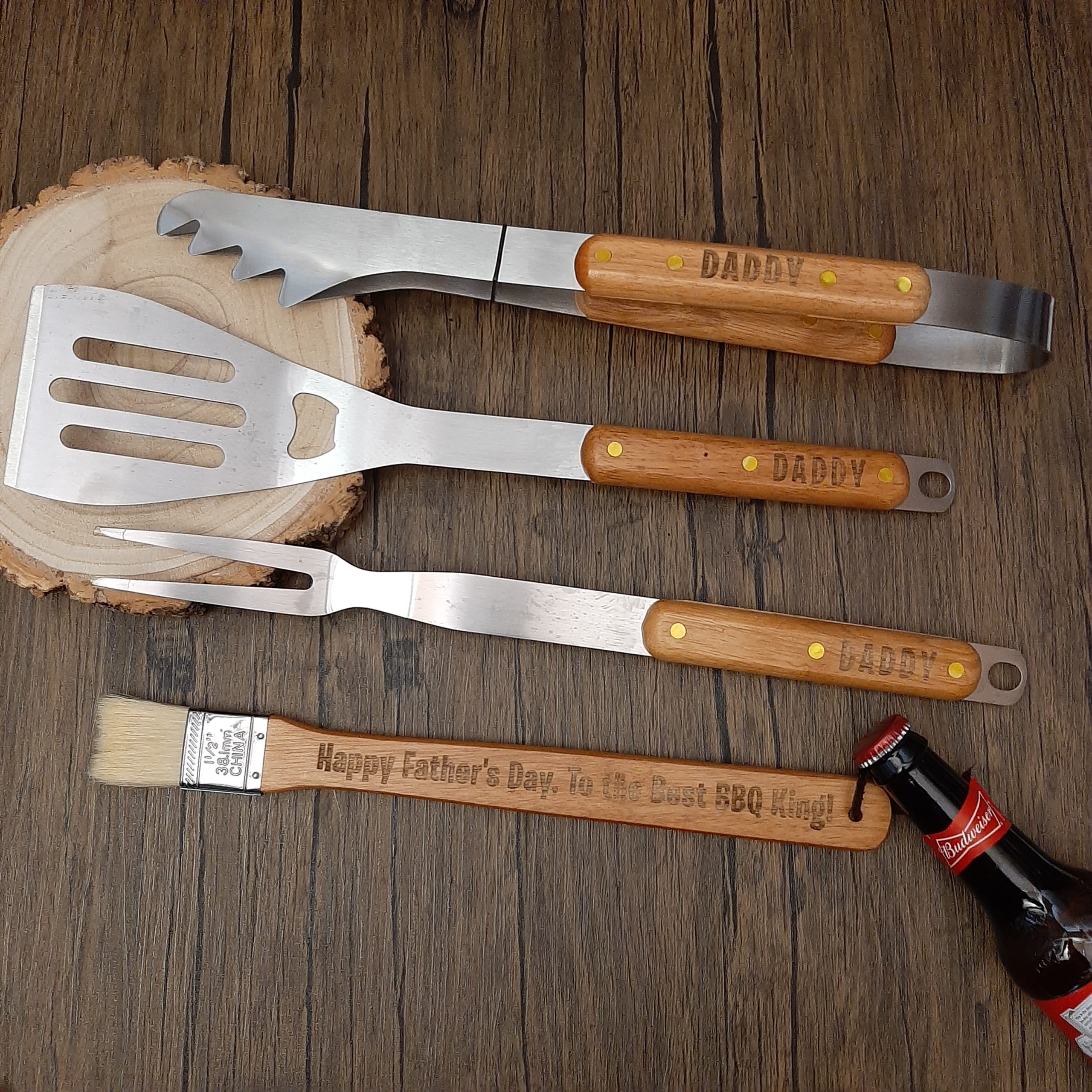 bbq utensil tool kit with wrapped carrier with personalised handles on display. engraved names