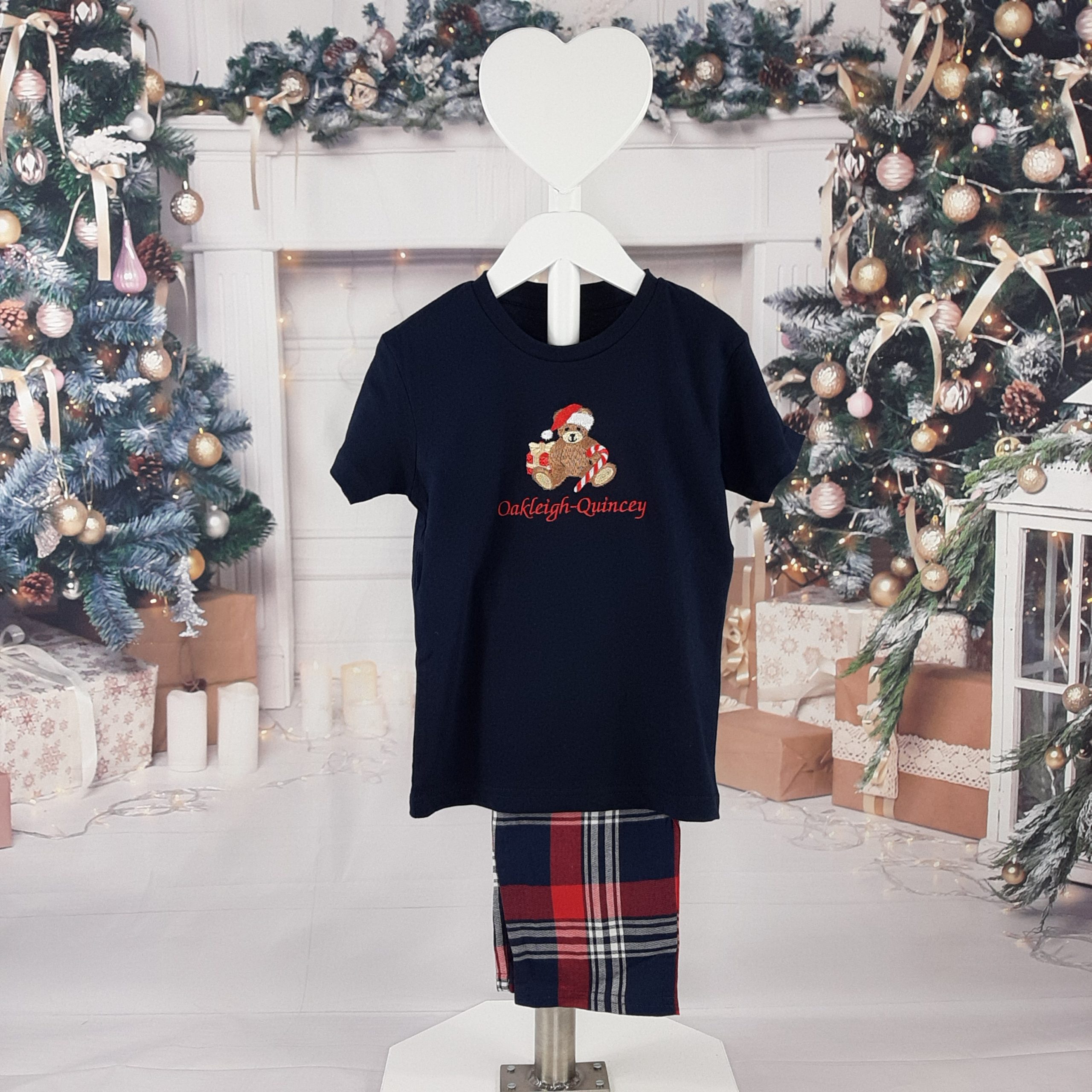Children's Tartan Teddy PJs are great pyjamas for christmas. All embroidered personalisation. Red name. on a stand