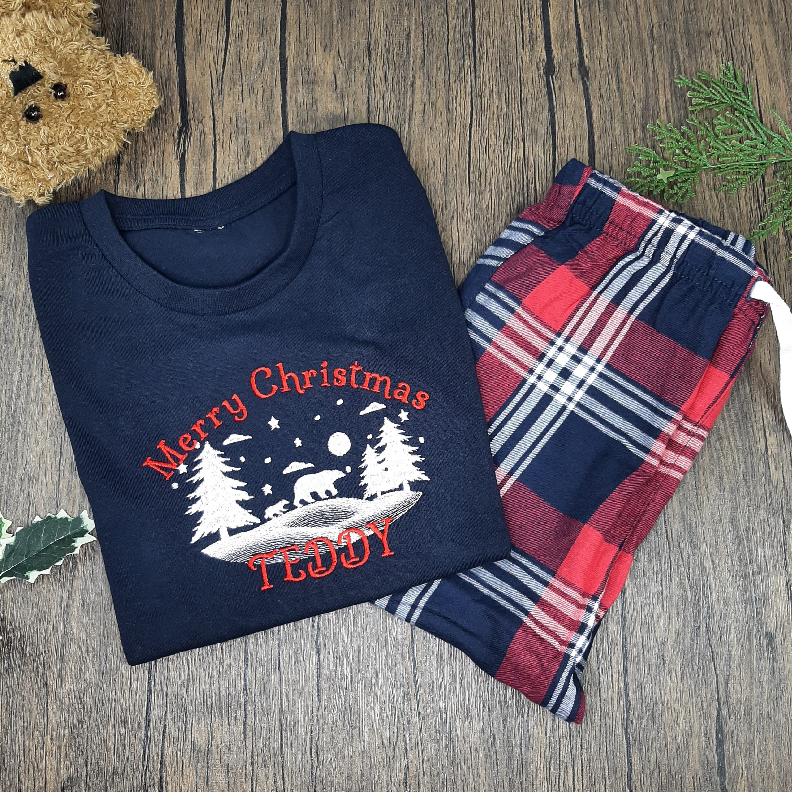 Family Tartan Winter PJs, children's tarten winter pjs are great pyjamas for christmas. Featuring polar bear snow scene. All embroidered personalisation. Red name. Laid with teddy
