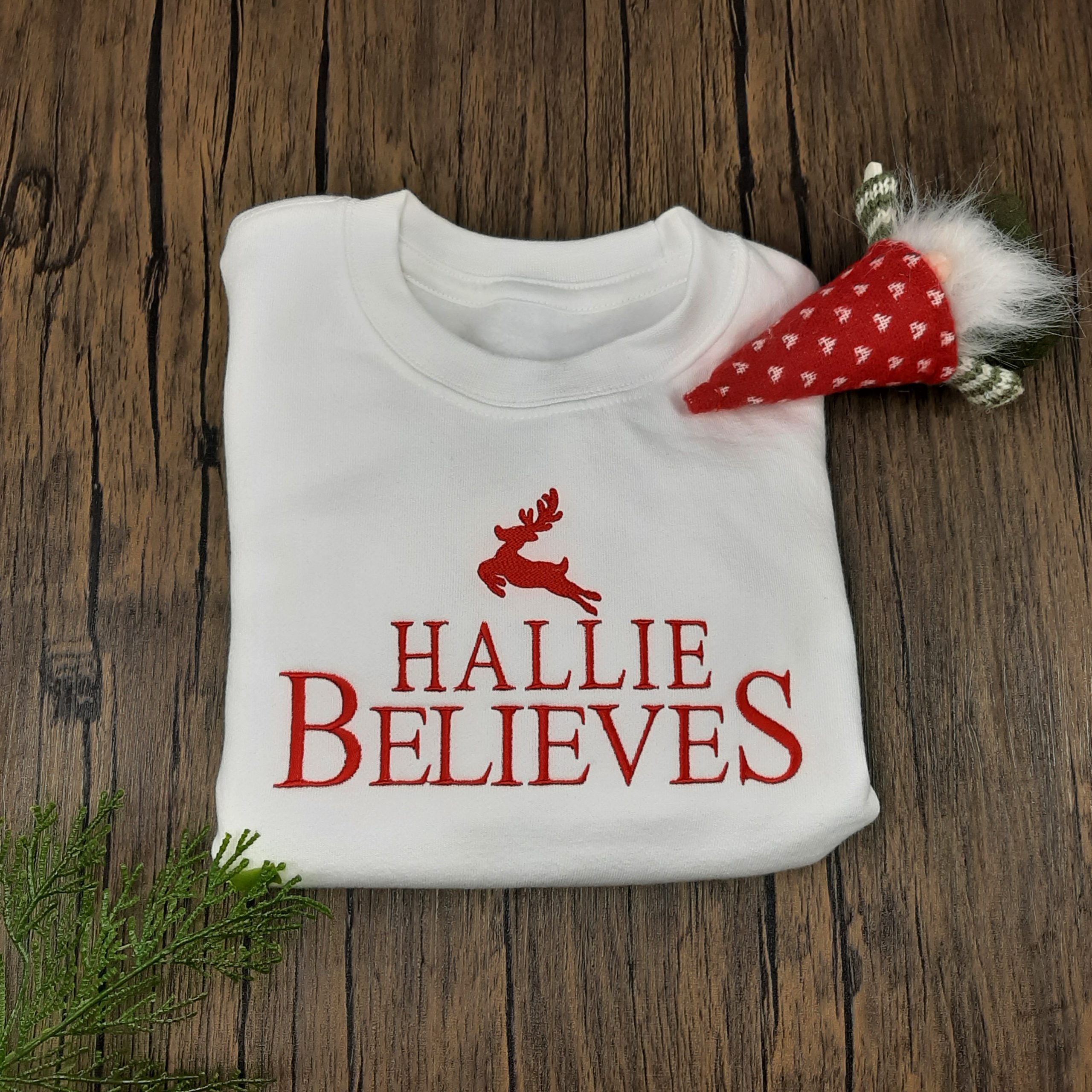 white Believes Christmas Jumper design featuring personalised name believes and cute reindeer all embroidered. folded