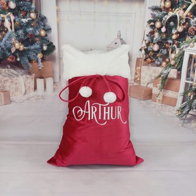 Luxury Personalised Christmas Sack in traditional red and white plush fabric, lined for durability and finished with fluffy pom poms. Generous size or stockings