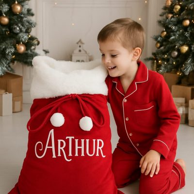 Luxury Personalised Christmas Sack in traditional red and white plush fabric, lined for durability and finished with fluffy pom poms. Generous size or stockings mock